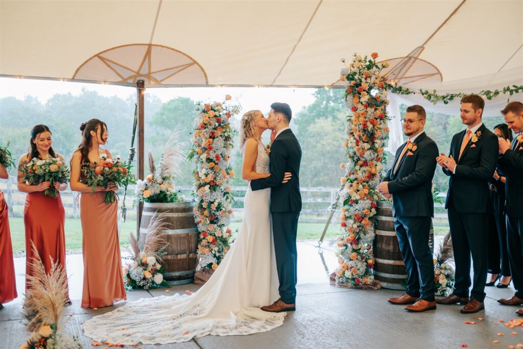 Bride and groom kissing at end of wedding ceremony at Robin Hills Farm in Chelsea Michigan