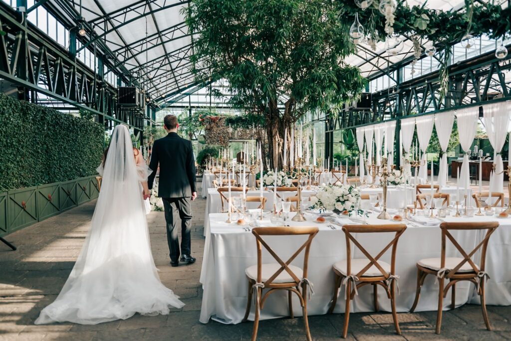 Bride and groom walking hand-in-hand at their Planterra Conservatory wedding reception