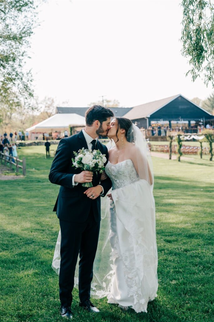 Bride and groom kissing after wedding ceremony at Westers Vineyard in Michigan