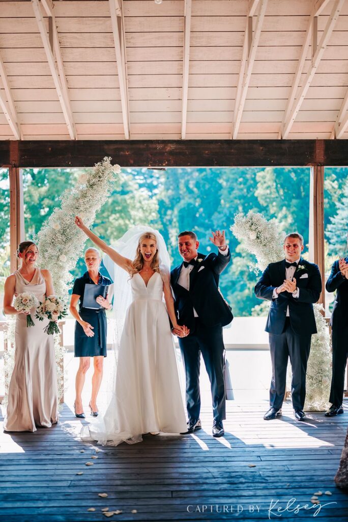 Couple waving after ceremony at Pine Knob Carriage House