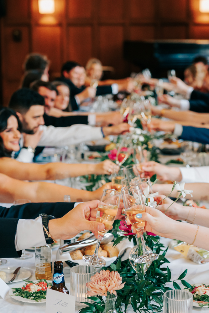 Wedding reception clinking glasses for a toast at Michigan League Wedding Reception